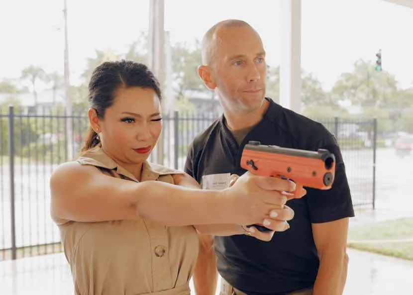 A first-time shooter being coached through a Byrna launcher on the outdoor range