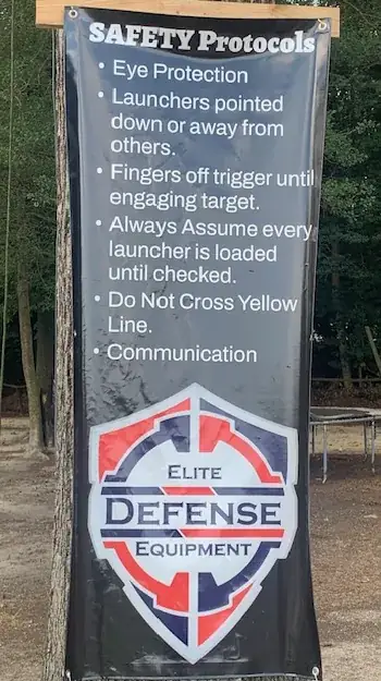 Elite Defense Equipment safety protocols banner posted on the outdoor range